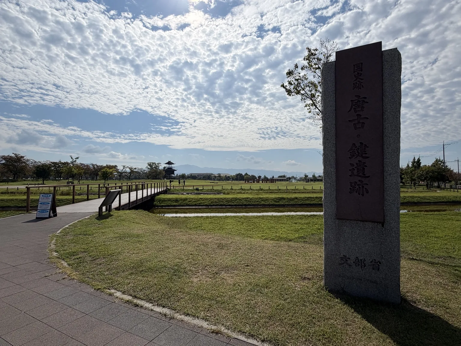 史跡の石碑と、その向こうに広がる園内。